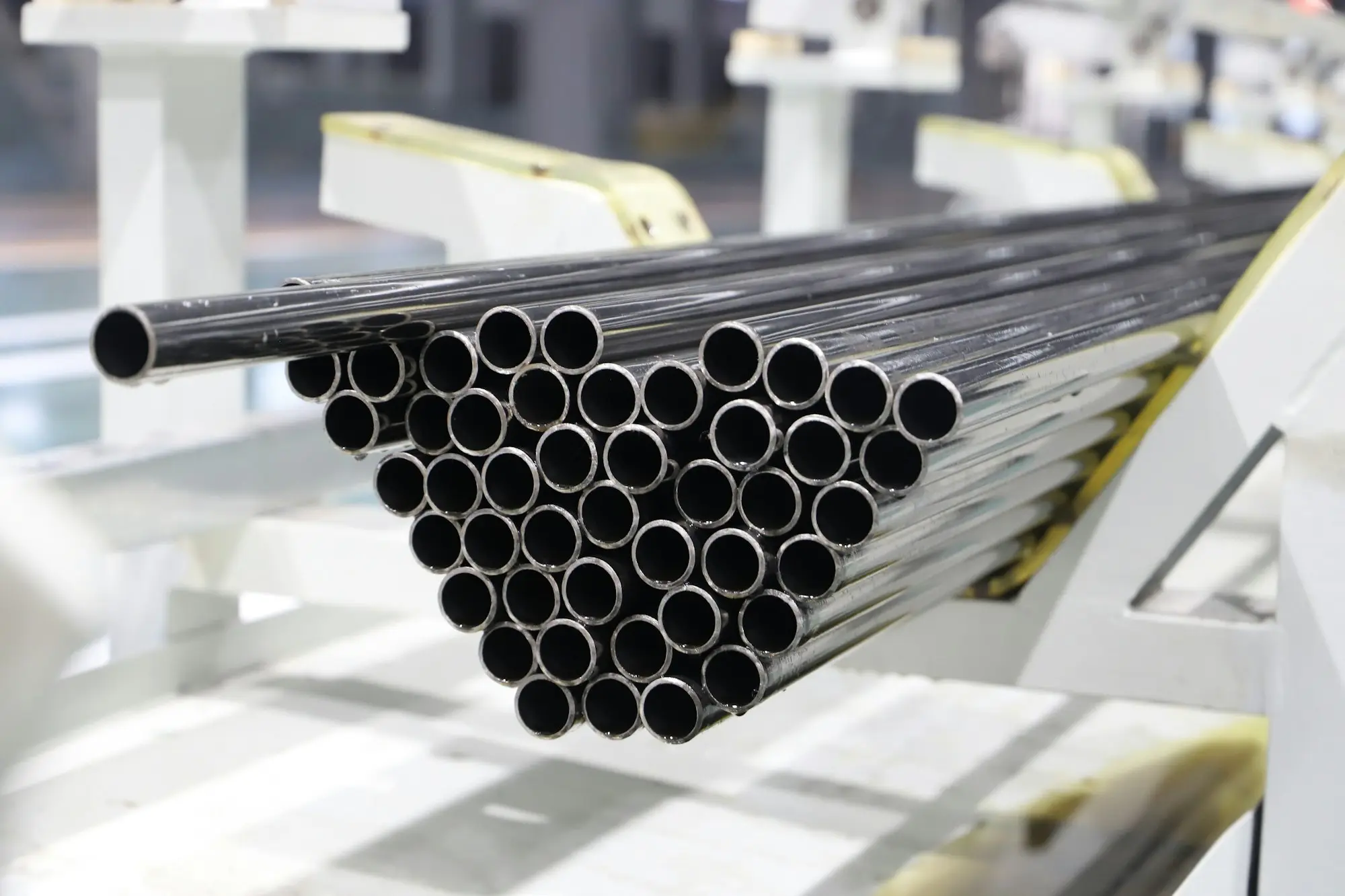 A bundle of polished steel pipes stacked on a finishing line