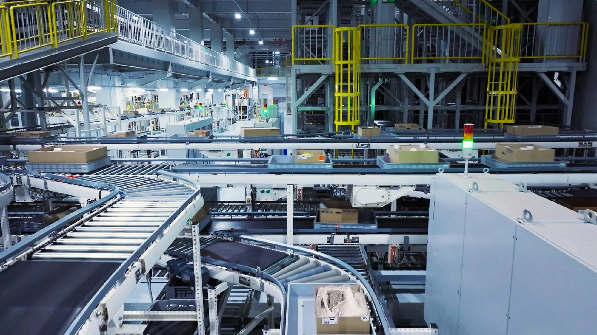 Conveyor lines carrying cartons through an automated packaging and logistics floor